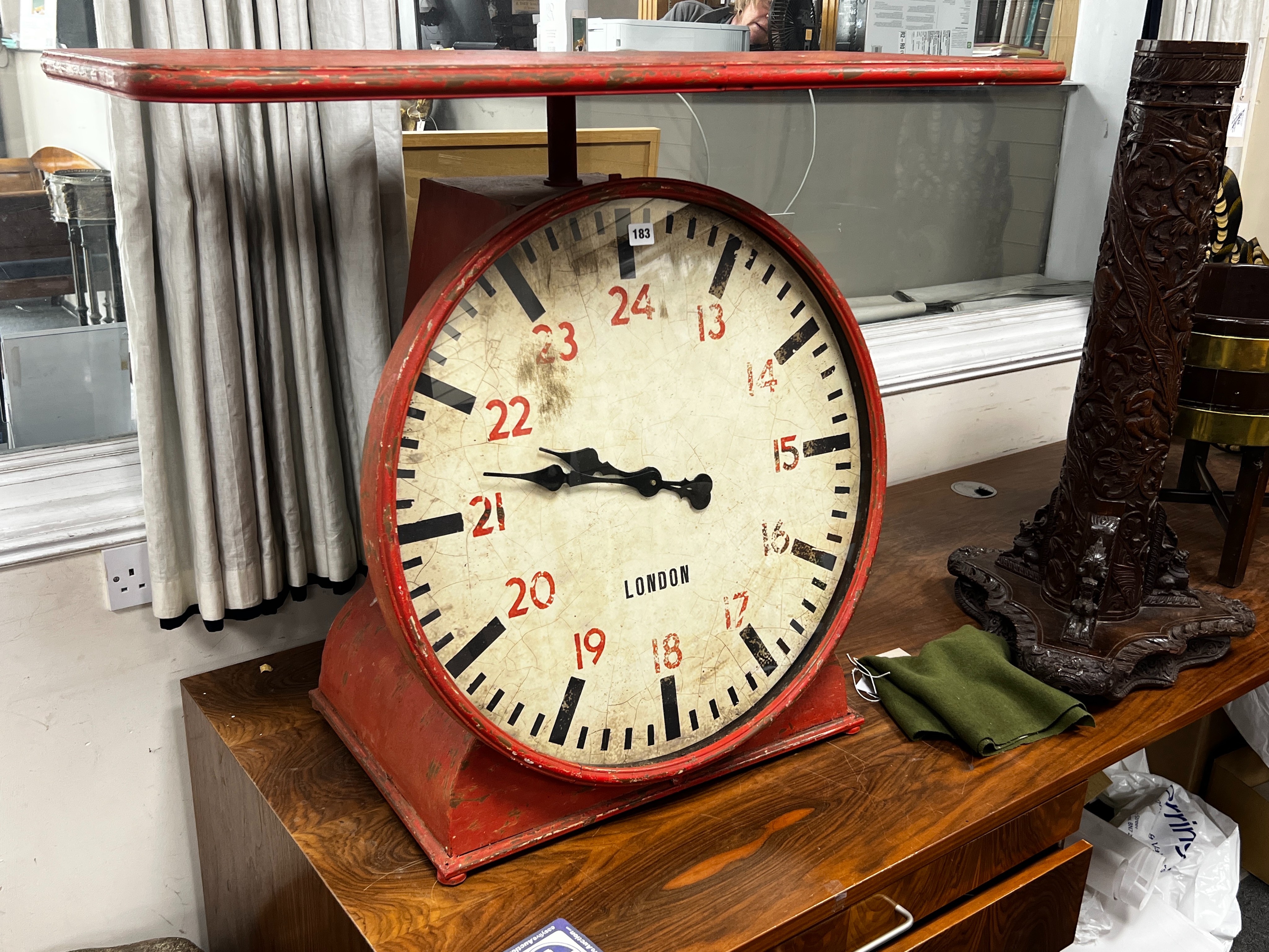 An industrial style painted metal clock console table modelled as a set of scales, width 102cm, depth 46cm, height 80cm.